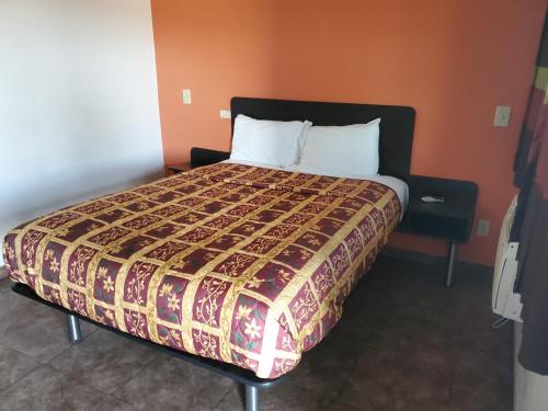 a bed in a hotel room with a large bed at High Desert Inn in Hesperia