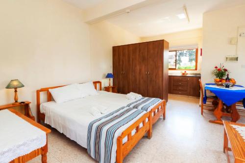 a bedroom with a large bed and a blue table at Follow The Sun Hotel Apartments in Polis Chrysochous