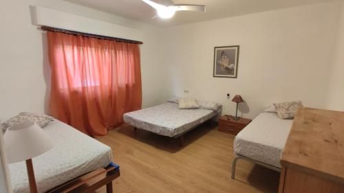 a room with two beds and a table with a lamp at Apartamento Vacaciones Granada in Granada