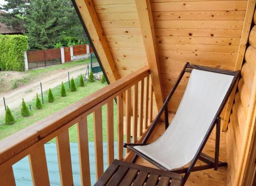 a rocking chair on the balcony of a log cabin at Brvnare Spasić in Vinci