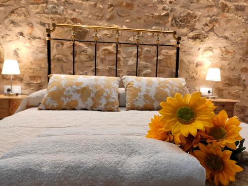 una camera da letto con un letto con fiori gialli di casa rural Sierra del Solorio (posada de Iruecha) a Iruecha