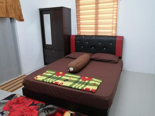 ein kleines Schlafzimmer mit einem Bett mit einer Decke darauf in der Unterkunft Amani Apartment Homestay in Malakka