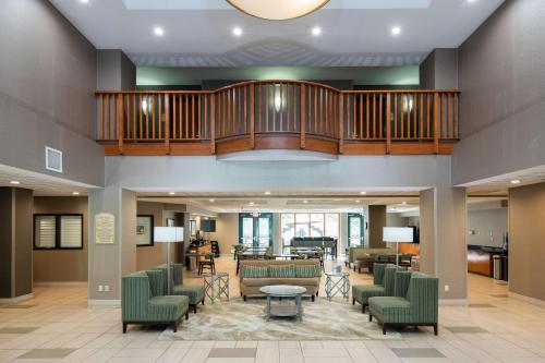a large lobby with green chairs and a staircase at Best Western Coyote Point Inn in San Mateo