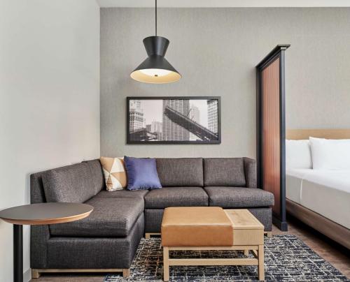 a living room with a couch and a bed at Hyatt Place Chicago Medical/University District in Chicago