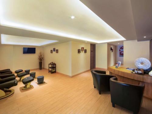 a waiting room with chairs and a barber shop at Novotel Pekanbaru in Pekanbaru