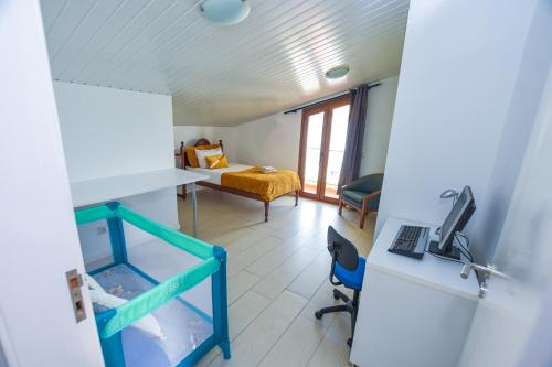 a room with a bed and a desk with a computer at A House near CR7 Museum Madeira in Funchal