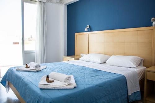 a blue bedroom with a bed with towels on it at Carlos Pension in Akrotiri