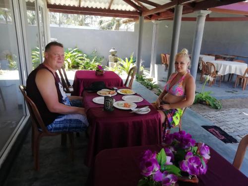 a man and a woman sitting at a table at Rainbow Beach Resort in Ambalangoda