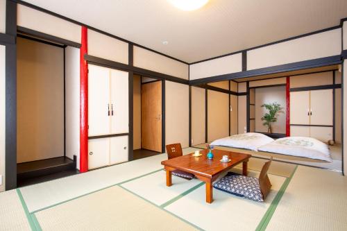 a bedroom with a bed and a table at The RYOKAN O in Nakatsugawa