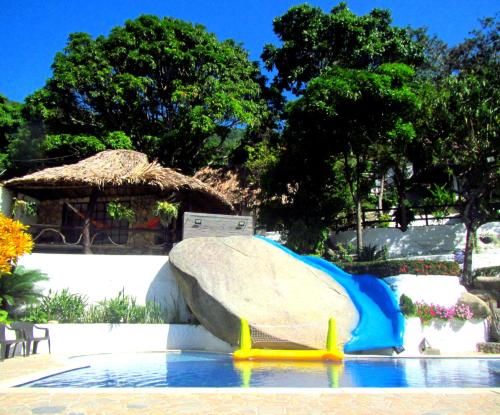 a water slide in a pool with a rock at Hostal Villa Cata in El Zaino