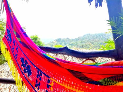 a red hammock with a mountain in the background at Hostal Villa Cata in El Zaino