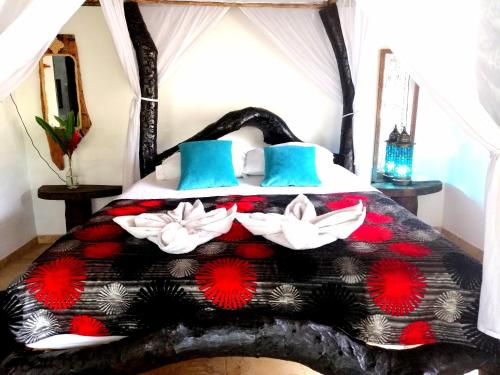 a bedroom with a black and red bed with flowers on it at Hostal Villa Cata in El Zaino