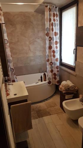 a bathroom with a tub and a toilet and a sink at Dimora La Risorgiva in Ca' di David
