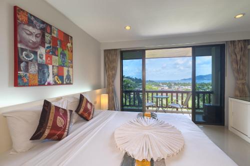 a bedroom with a white bed and a large window at Sea Hills Resort in Patong Beach