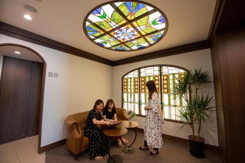 two women in a waiting room with a stained glass window at Stay SAKURA Tokyo ASAKUSA ART DECO HOTEL in Tokyo