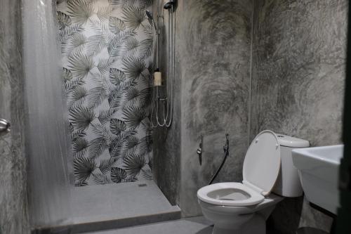 a bathroom with a shower with a toilet and a sink at Baan Khun Pra Duplex Rm3 Bangkok in Bangkok