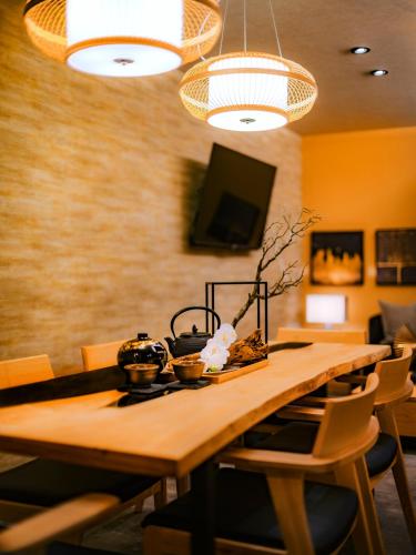 a dining room with a wooden table and chairs at SAMURAI HOUSE Ⅲ in Nagoya