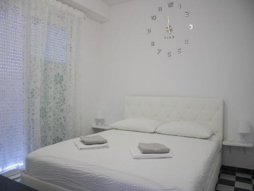 a bedroom with a white bed with two towels on it at Apartments Jurković in Neum