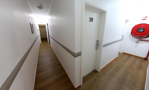 a hallway with white walls and wooden floors at Sun Hotel in Brussels
