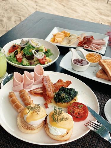 a table with three plates of food on it at Buri Rasa Village Phangan in Thong Nai Pan Noi