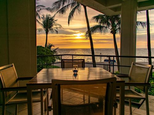 a table and chairs on a porch with a view of the ocean at The Moon Beach Museum Resort in Onna