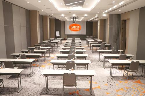 an empty room with desks and a sign on the wall at HARRIS Hotel & Conventions Bundaran Satelit Surabaya in Surabaya