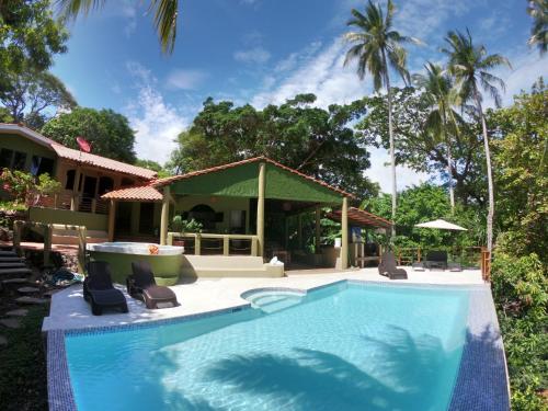 una piscina davanti a una casa con palme di Lagarza Hostel a La Libertad