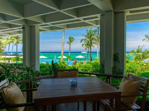 an outdoor patio with a table and chairs and the ocean at The Moon Beach Museum Resort in Onna