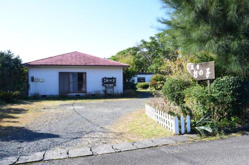 a house with a sign on the side of a road at Yakushima Minsyuku Suginoko in Yakushima