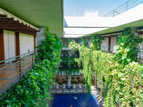 an ivy covered building with a swimming pool at The Moon Beach Museum Resort in Onna