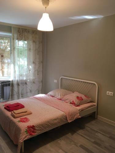 ムーロムにあるApartment on Mechnikovaのベッドルーム1室(ピンクのシーツが敷かれたベッド1台、窓付)