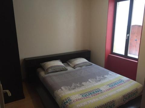 a bedroom with a bed with two pillows and a window at CHAPELLE ST NICOLAS in Roanne