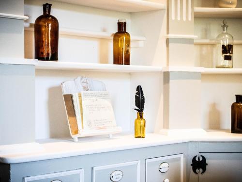 a shelf with bottles and a book on it at A Casa da Botica in Samos