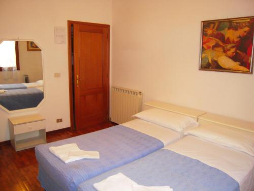 1 Schlafzimmer mit 2 Betten und einem Spiegel in der Unterkunft Riva Reno GuestHouse in Bologna