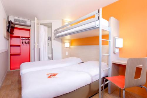 ペサックにあるPremiere Classe Bordeaux Sud - Pessac Becquerelのオレンジ色の壁の客室で、二段ベッド2台が備わります。
