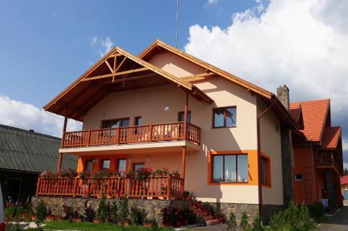 a house with a balcony on top of it at Pensiunea Teo in Bilbor