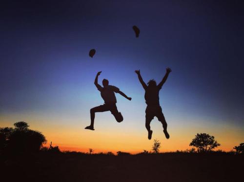 two people jumping in the air at sunset at Makumu Private Game Lodge in Klaserie Private Nature Reserve
