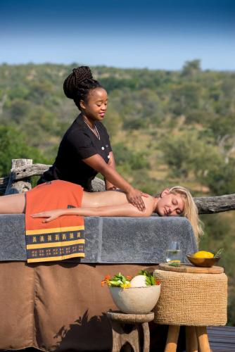 a woman laying on a couch next to a woman at Makumu Private Game Lodge in Klaserie Private Nature Reserve