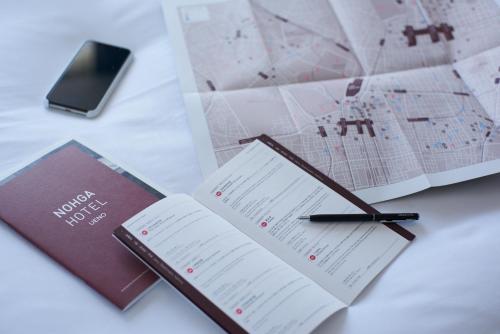 a book and a pen on a table with a map at NOHGA HOTEL UENO TOKYO in Tokyo
