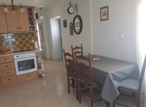 a kitchen with a table and chairs and a stove at VERANDA BLUE - POROS in Poros