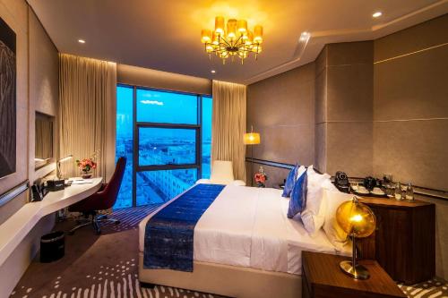 a hotel room with a bed and a large window at VIP Hotel Doha Qatar in Doha