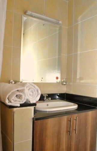 a bathroom with a sink and a mirror at West suites home -with a view in Nairobi
