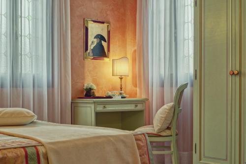a bedroom with a bed and a table and a lamp at Hotel Firenze in Venice