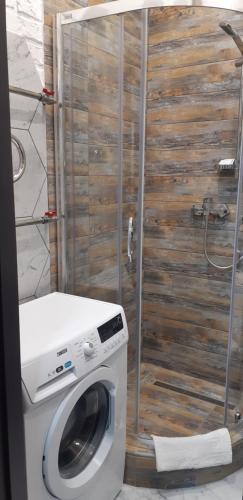 a washing machine in a bathroom with a wooden wall at Apartment on Soborna 91 in Vinnytsya