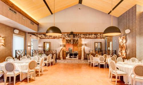 a banquet hall with white tables and chairs at Ansares Hotel in Tarancón