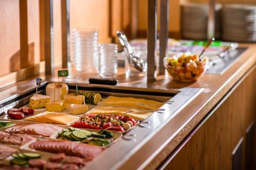 a buffet line with meats and cheese and other foods at Hotel Garni Zur Alten Post in Lembruch