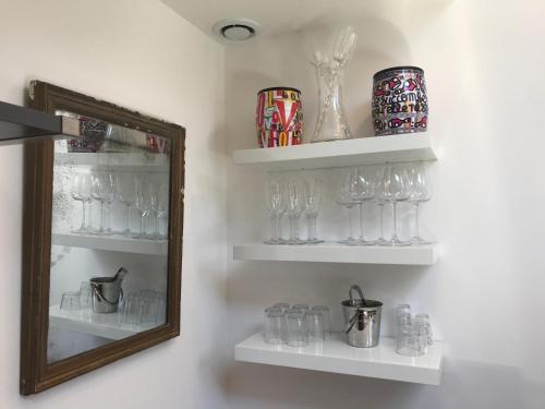 a room with shelves with glasses and a mirror at Loft Mahanoa in Cabannes