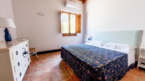 Schlafzimmer mit einem Bett und einem Fenster in der Unterkunft La Casa del carrubo di Borgo Carbone in Locri