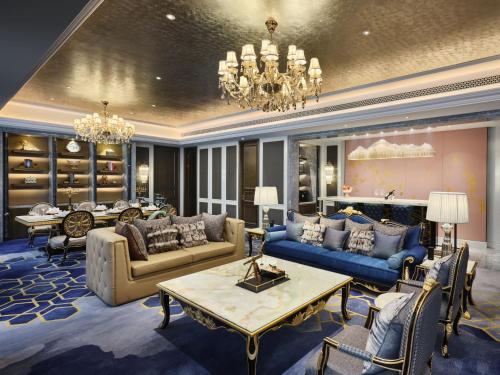 a large living room with blue furniture and a chandelier at Wanda Vista Changchun in Changchun