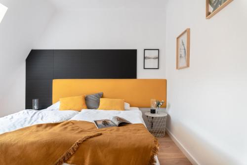 a bedroom with a large bed with a yellow headboard at LeoApart in Wrocław